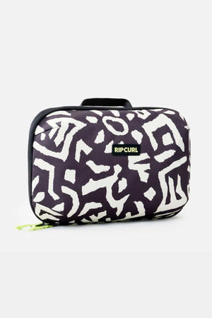 The Rip Curl Ultimate Beauty Case features a stylish black and white pattern, ideal for storing your beauty essentials. Its rectangular shape displays abstract white shapes against a black background, and it comes with a small handle on top. The brand name "RIP CURL" is prominently displayed on a black and green label at the front center of the bag.