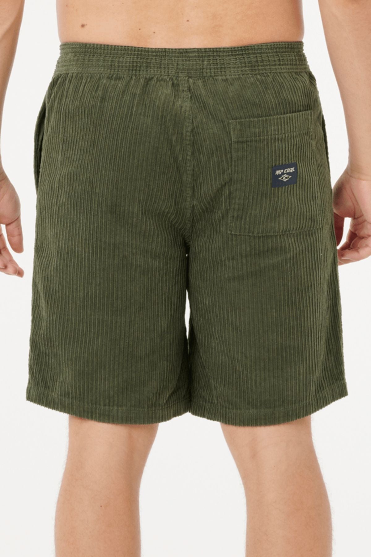 A person wearing olive green Rip Curl Classic Surf Cord Volley shorts, viewed from the back. The shorts feature a visible back pocket with a small navy patch. The background is plain white.