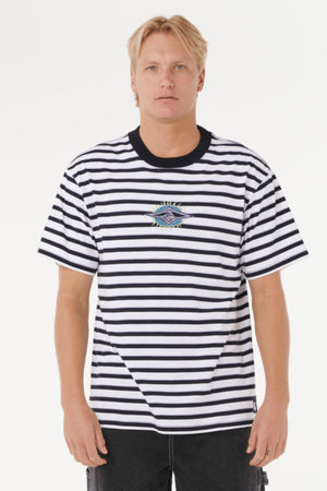 A blond-haired person wears a Rip Curl Raw Energy Stripey Tee, a black-and-white striped cotton jersey with an embroidered chest logo, standing against a plain white background.