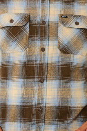 Close-up of the Rip Curl Count Flannel Shirt in brown, blue, and cream, made from heavy brushed fabric with two chest pockets and front brown buttons—a cozy, sustainable style option.