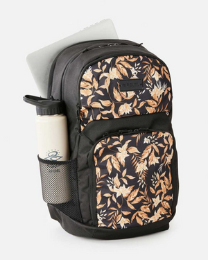 The Rip Curl Chaser 33L Backpack features a brown and white floral print, mesh side pocket for a water bottle, and a main compartment that fits a 15-inch laptop.