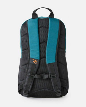 The Rip Curl Overtime 30L Journeys Backpack is an eco-friendly teal and black bag with padded shoulder straps, a top black handle, a small orange logo on one strap, and a chest buckle clasp.