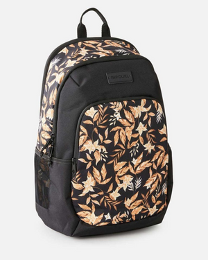 The Rip Curl Ozone 2.0 30L Backpack is black with tan and white leaf patterns on the top section, features a front pocket and mesh side pocket, is made from recycled polyester, and is shown against a white background.