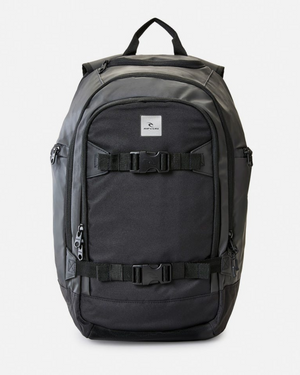 The Rip Curl Posse 33L Backpack in black features a top handle, two large front zippered compartments, two horizontal buckle straps, side pockets (one insulated for drinks), and a small white rectangular logo on the upper front.