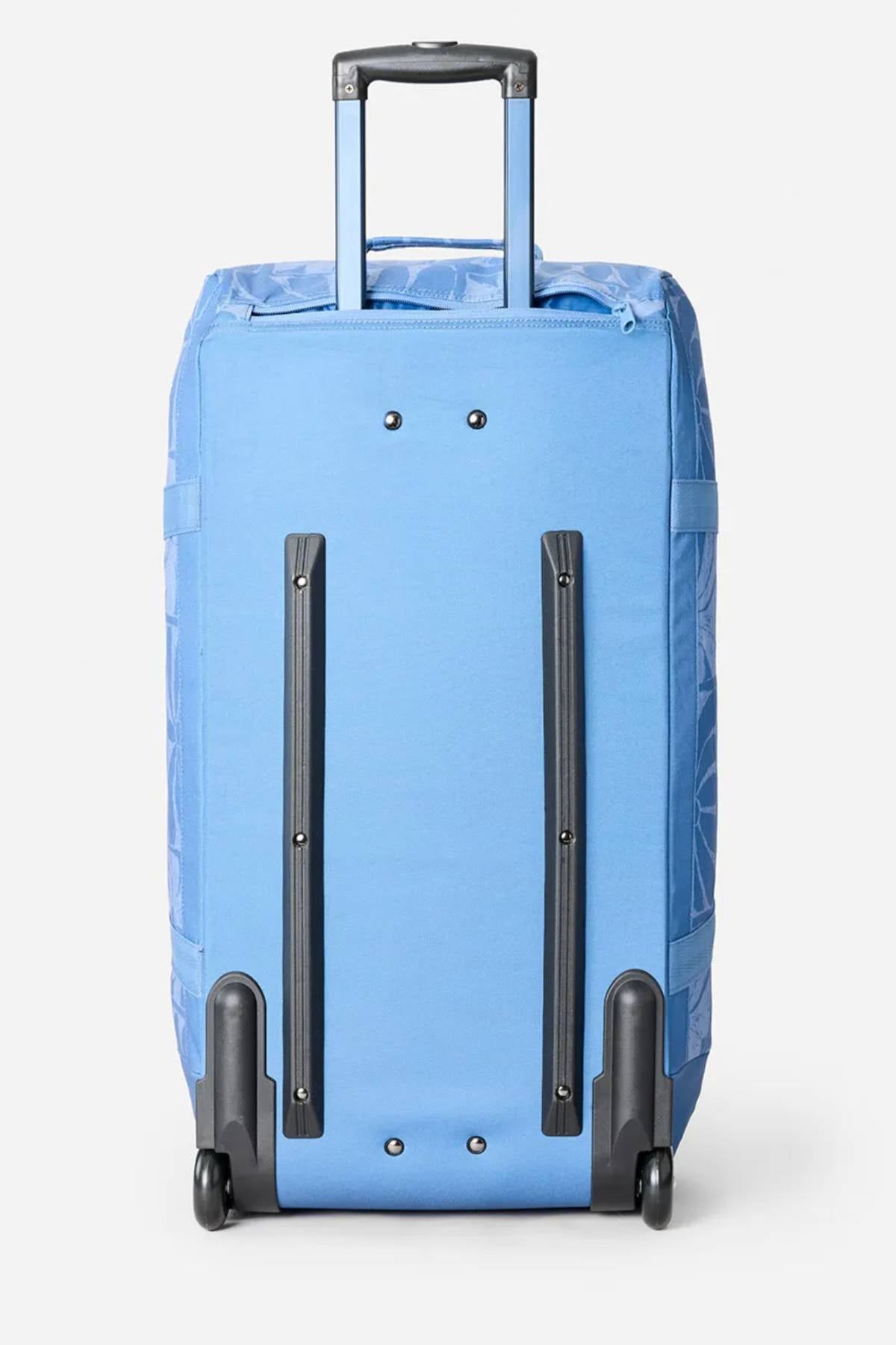 The Rip Curl Jupiter 80L Mixed Travel Bag, shown upright on a white background, features light blue recycled polyester, a retractable handle, two wheels, and two black protective back rails.