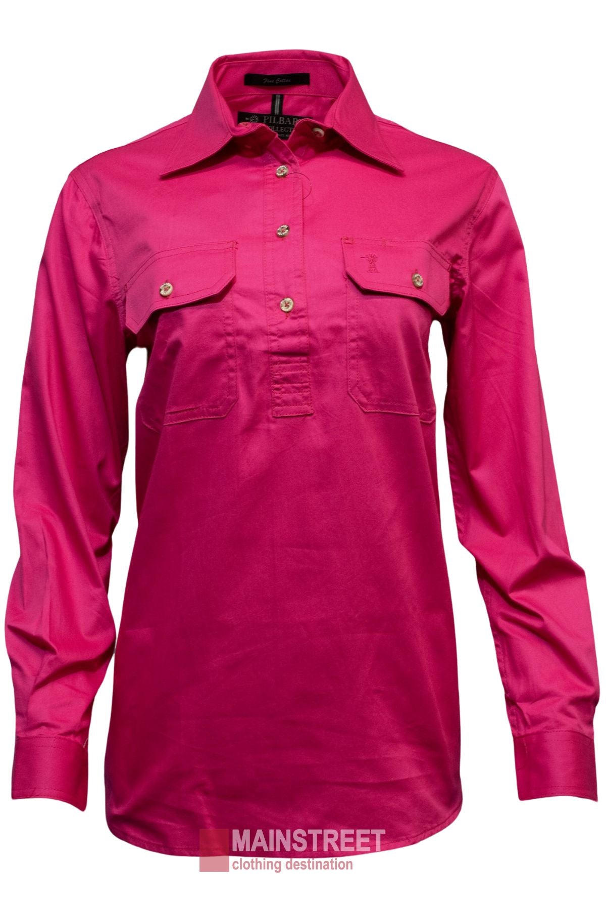 The Pilbara Ladies Long Sleeve Closed Front Shirt is a bright pink, 100% cotton womenβs work shirt with two chest pockets, a collar, and UPF 50+. Displayed on white with the "MAINSTREET clothing destination" logo at the bottom.