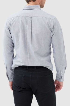 A man is seen from behind wearing the Rodd & Gunn Gunn Oxford Sports Fit Shirt in light gray, made from 100% cotton, paired with black pants. His hands hang by his sides against a plain, neutral background.
