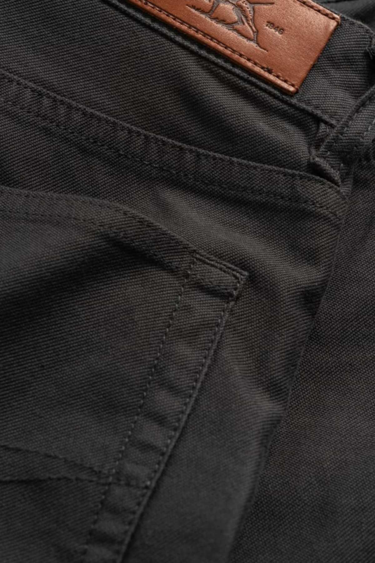 Close-up of Rodd & Gunn Motion 2 Straight Jean in black denim, showcasing comfort stretch fabric, a side pocket, a brown leather patch on the waistband, and a durable YKK zip fly.