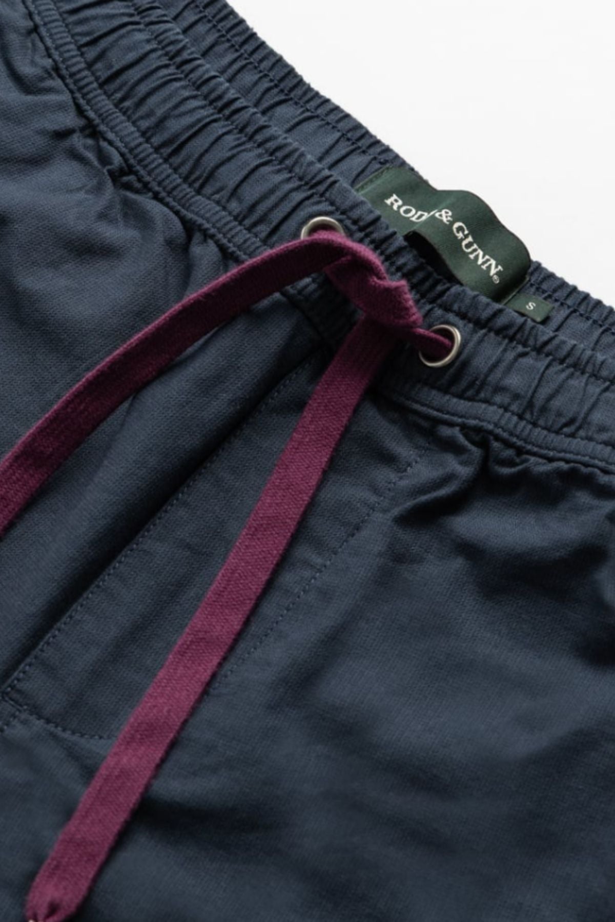 Close-up of Rodd & Gunn Resort Short in navy with deep purple drawstrings, metal eyelets, and a branded inner waistband—stylish cotton shorts designed for all-day comfort.