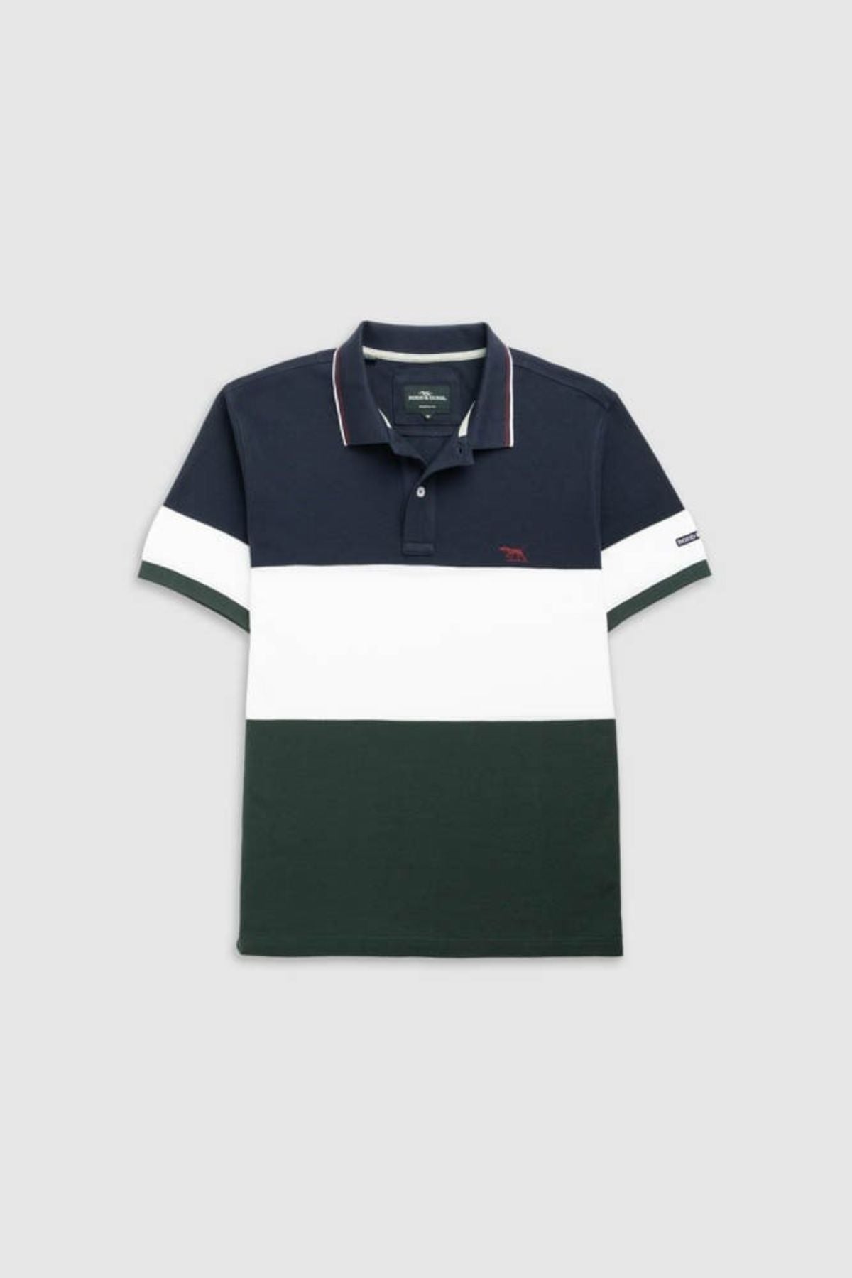 The Rodd & Gunn Homebay Polo features a color-blocked sports fit with navy top, wide white stripe, dark green bottom, collar, short sleeves, and embroidered logo. Crafted from sustainable Australian Good Earth Cotton for comfort and style.