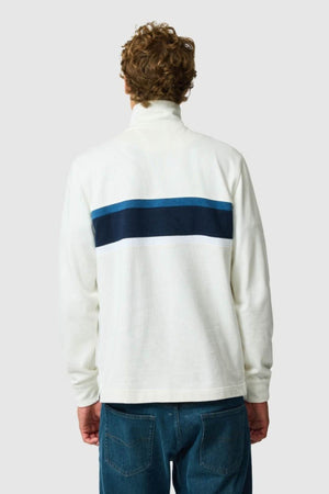 A person with curly hair, seen from the back, wears the Rodd & Gunn Chesterfield Sweat with blue stripes and blue jeans—highlighting eco-conscious style against a plain light gray background.