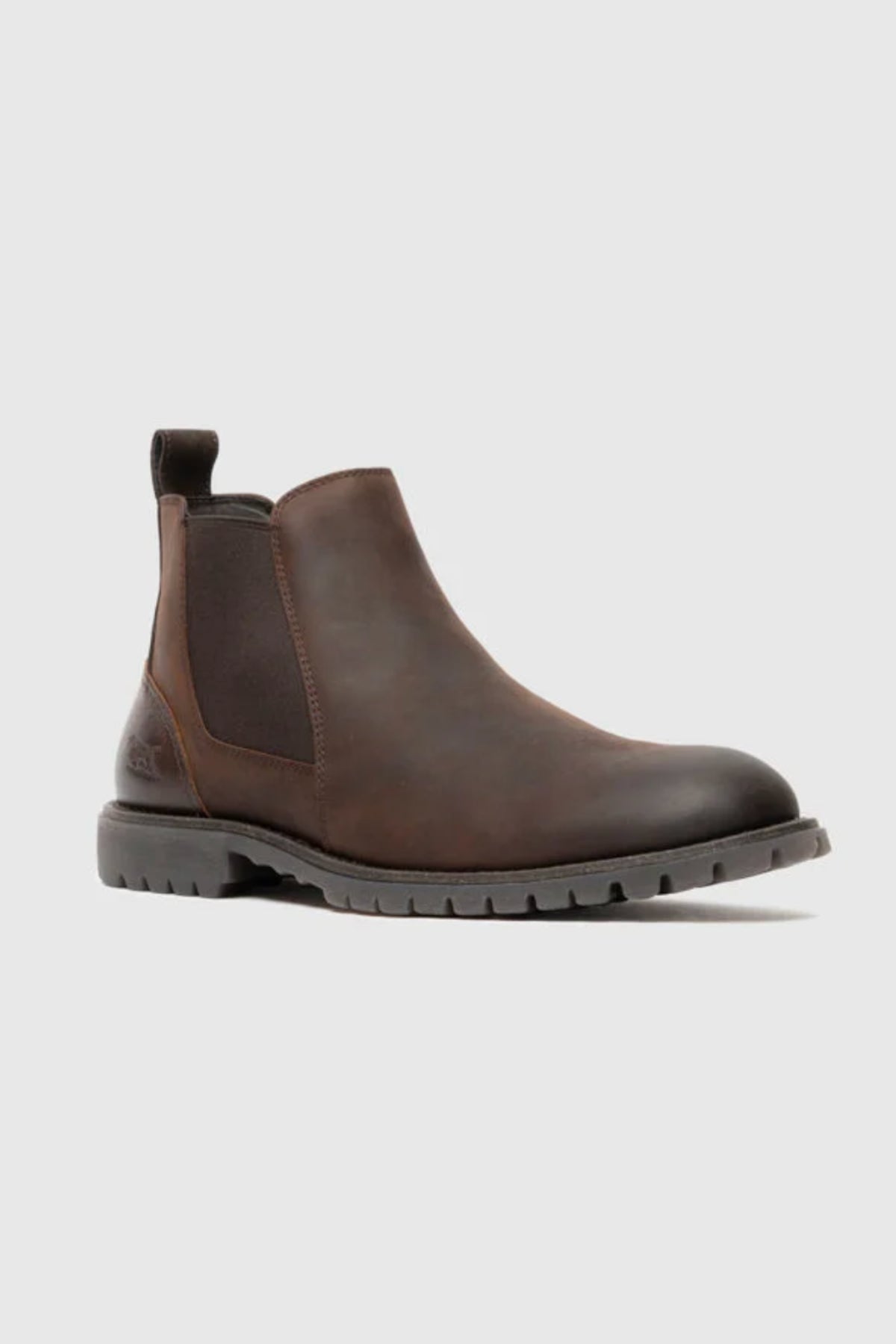 The Rodd & Gunn Clearmont Chelsea Boot, crafted in brown leather with elastic side panels, a back pull tab, and a rugged textured sole, is showcased against a plain light gray background for a comfortable and stylish look.