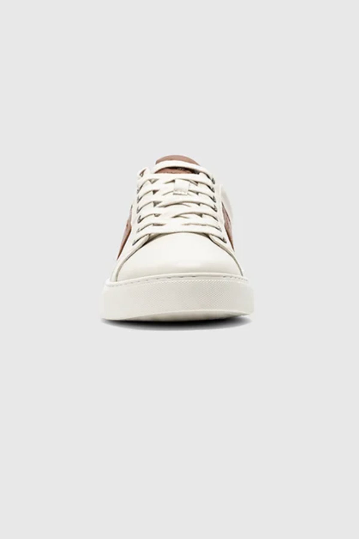 A front view of the Rodd & Gunn Endeavour Cruise Sneaker, featuring white leather, beige laces, and a brown side accent, shown against a plain light gray background.