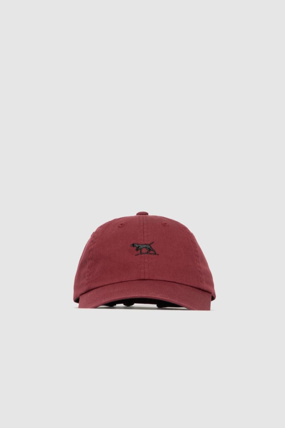 The Rodd & Gunn Gunn Cap is a maroon cotton twill cap featuring a small black pointer dog logo embroidered on the front, shown against a plain light gray background.