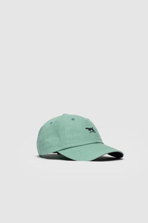 The Rodd & Gunn Gunn Cap is a light green cotton twill hat featuring a small black dog embroidered on the front, shown against a plain light gray background.
