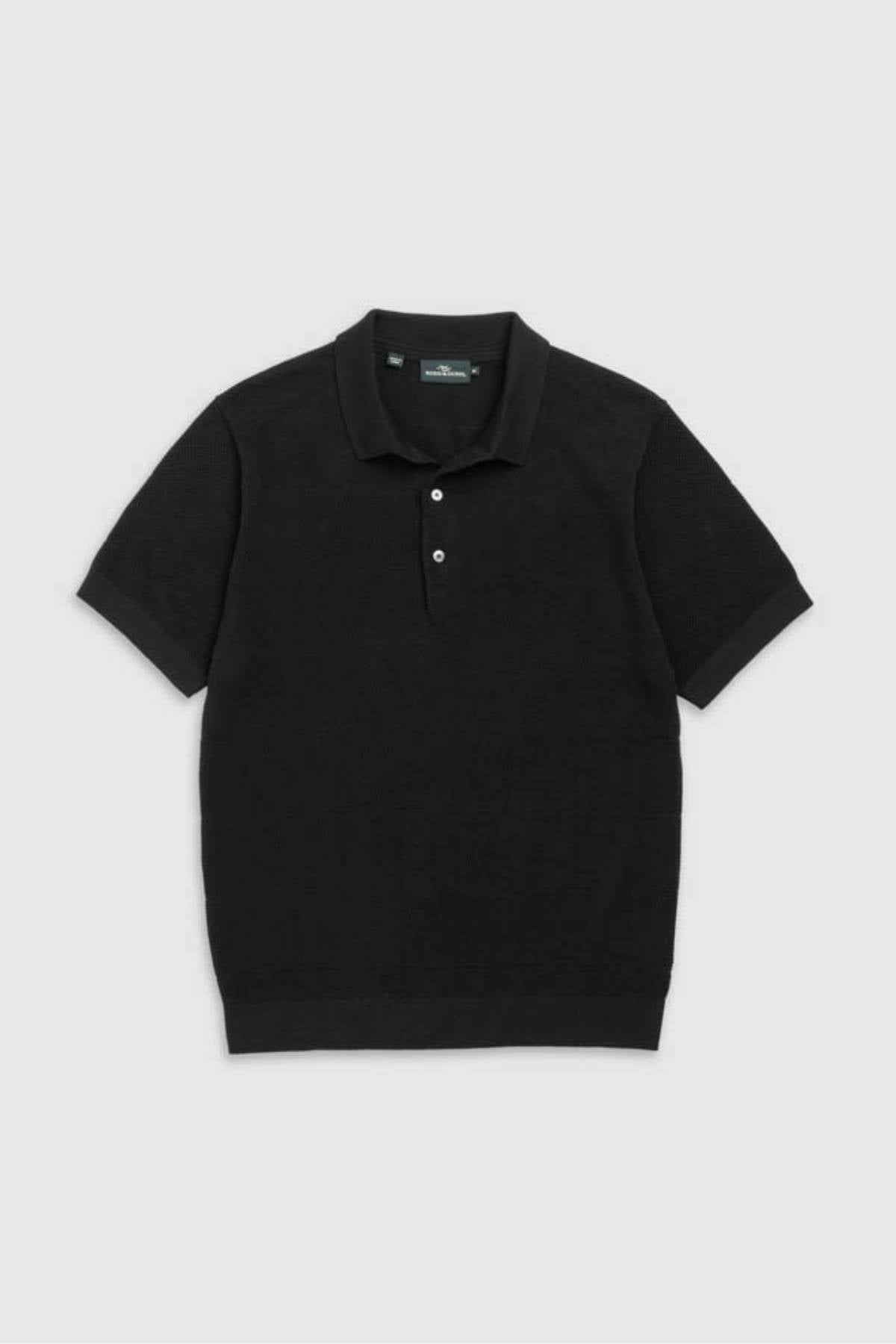 The Rodd & Gunn Masons Flat Knit is a men's black short-sleeve polo with a collar and three buttons, made from cotton pique and shown laid flat on a light gray background.