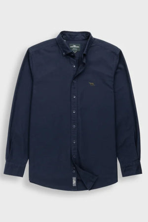 Rodd & Gunn Gunn Oxford Sports Fit Shirt in dark navy with long sleeves, collar, buttoned cuffs, and a small embroidered animal logo on the left chest. Made of 100% cotton and shown laid flat on a light gray background.