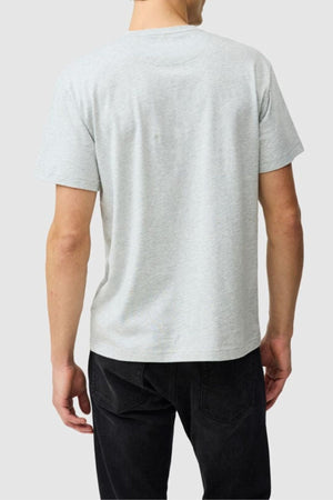 A person is shown from the back wearing a light gray Rodd & Gunn The Logo Tee 2.0 and black jeans against a plain light gray background.