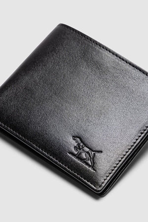 The Rodd & Gunn Wakefield Bi-Fold Wallet is a sleek black Italian leather wallet with stitched edges and an embossed dog outline on the lower right corner, shown against a light gray background.