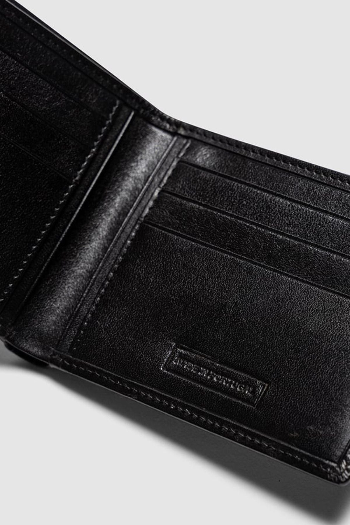 A close-up of the Rodd & Gunn Wakefield Bi-Fold Wallet in black Italian leather, displaying multiple card slots on both sides, photographed against a plain light gray background.