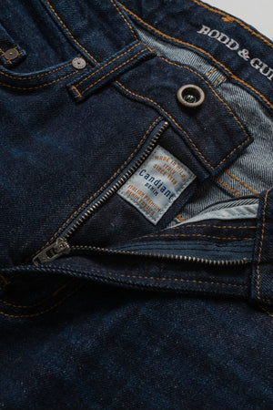 Close-up of Rodd & Gunn Sutton Straight Italian Denim Jean in dark blue, featuring a partially open zipper that reveals the "Candiani Denim" interior label and signature Rodd & Gunn stitching on the waistband.