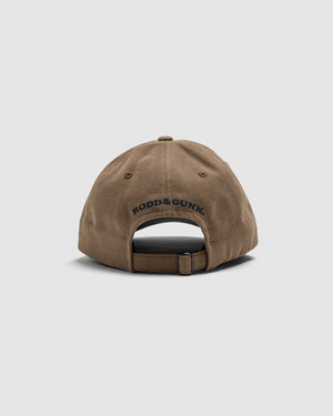 The Rodd & Gunn Signature Cap is a brown cotton twill cap shown from the back, featuring an adjustable strap and "RODD & GUNN" embroidered above the opening.