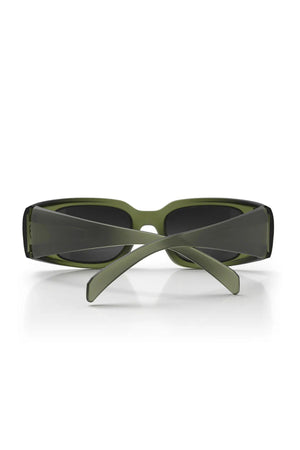 The SafeStyle Auras features a matte moss green rectangular frame and grey polarised lenses, shown from the back with crossed arms, resting on a white surface.