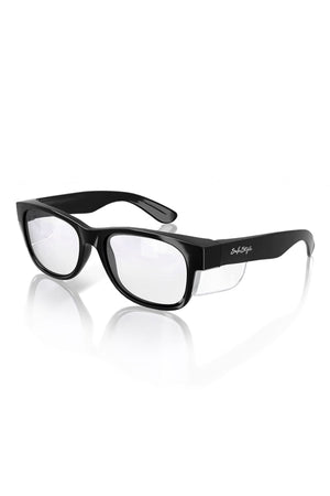The SafeStyle Classics Black Frame Clear Lens features wide rectangular frames with clear lenses. The sleekly designed arms include a logo inscribed on the side, and these UV-protective glasses are displayed on a white surface that shows a slight reflection.