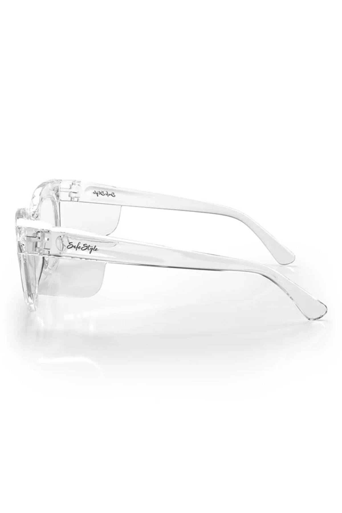 SafeStyle Harps Clear Frame Clear Lens safety glasses with shatterproof frames, UV400 protection, wraparound arms, and side shields. Shown from the side on a white background with the "SafeStyle" logo on the frame.