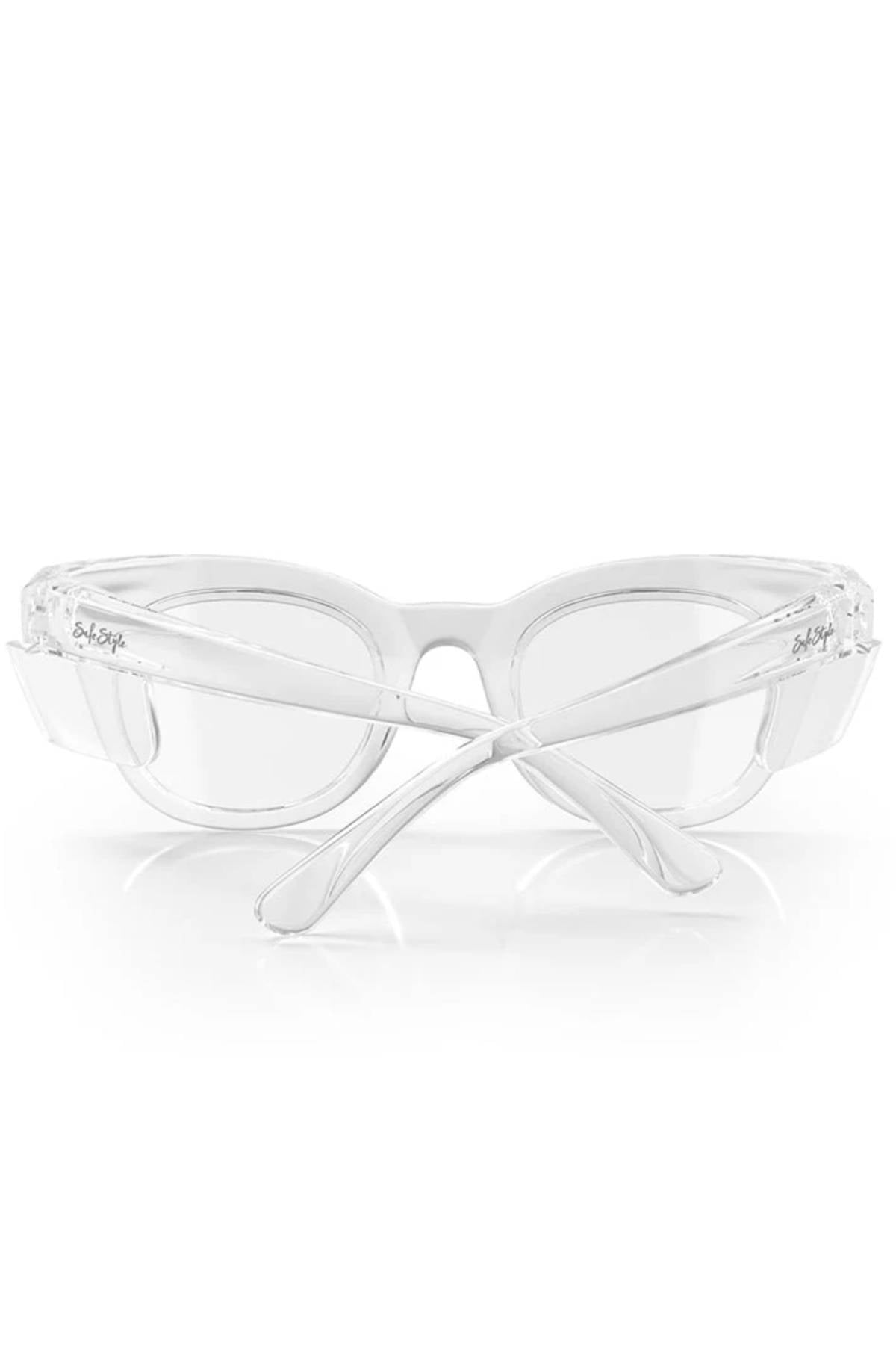 The SafeStyle Harps Clear Frame Clear Lens safety glasses, featuring UV400 protection and transparent, shatterproof frames, are shown from the back with their arms crossed on a white background.