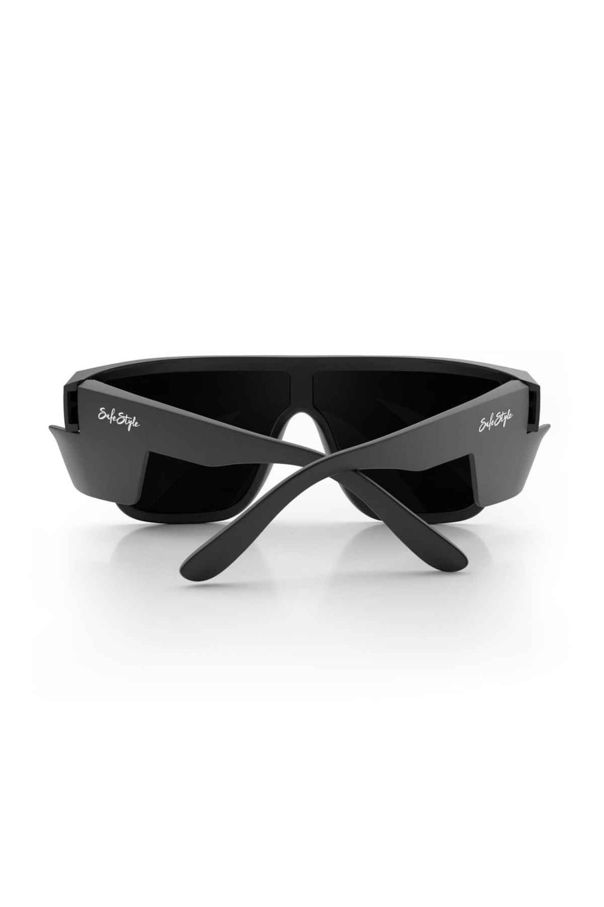 The SafeStyle Primes offer a rear view of matte black frames with crossed temples featuring a silver logo on the arms. The dark rectangular lenses are shatterproof polycarbonate, combining durability and style.