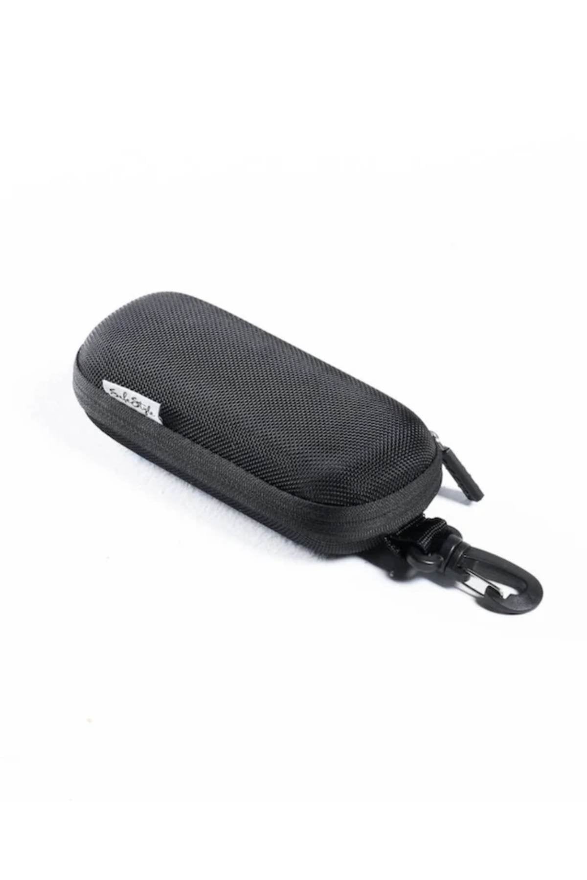 The Safestyle Hardcase is a compact black zippered sunglasses case made of durable nylon, featuring a fabric tag and an easy-release clip for convenient carrying. Shown against a white background.