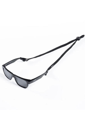 Black rectangular Safestyle sunnies with dark lenses are attached to a Safestyle Lanyard, which has an adjustable slide knot and the brand's logo near the temples. They are set against a plain white background.