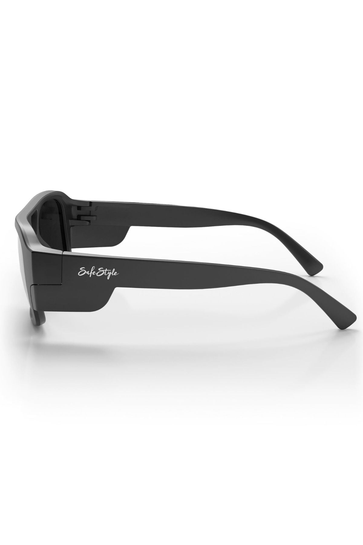 A side view of the Safestyle Skylines sunglasses showcases a matte black frame, thick arms with a white "SoftStyle" logo near the hinge, and grey polarised lenses reflecting light on a white background.