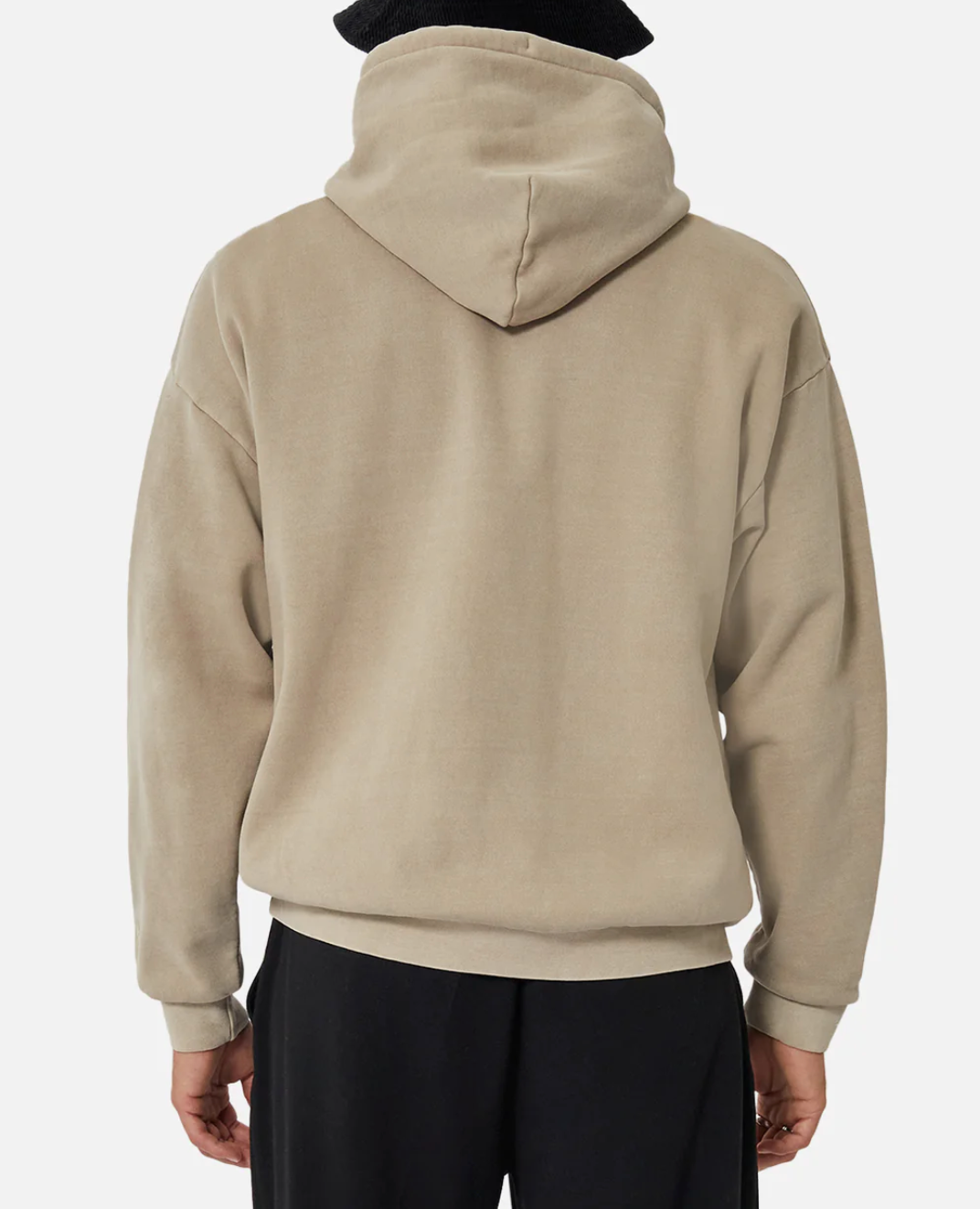 Someone wearing the Industrie The Del Sur Hoodie in an oversized beige fit with the hood up, viewed from the back. They pair it with black pants and stand against a plain white background.