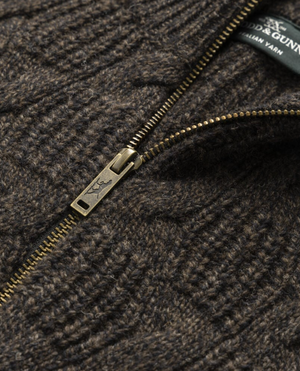 Close-up of the Rodd & Gunn Challis Knit sweater in textured brown lambswool, featuring a partially open brass zipper and a visible section of the fabric tag near the collar.