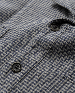Close-up of the Rodd & Gunn Pentland Hills Shirt in 100% cotton, featuring a small gray and blue houndstooth pattern, two black buttons, and a visible pocket seam.
