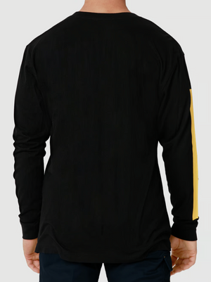 From behind, a person is seen wearing a CAT Icon Block Long Sleeve Tee with yellow stripes. The crew neck shirt is made from 100% cotton and paired with dark pants. The individual's head is not visible.