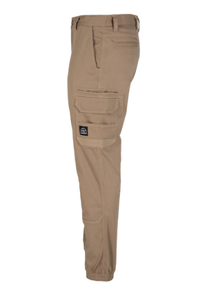 Side view of the UNIT Demolition Cargo Cuffed Pant in beige, made from durable stretch fabric with cargo pockets and a black patch. Features include an elasticated ankle cuff and waist belt loops, providing both style and functionality.