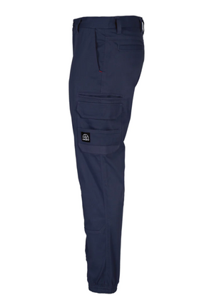 Side view of the UNIT Demolition Cargo Cuffed Pant in blue, showcasing cargo-style thigh pockets and an elastic ankle cuff. A small logo patch adorns the side pocket. Made from durable stretch fabric with UPF 50+ protection, these pants are ideal for outdoor adventures.