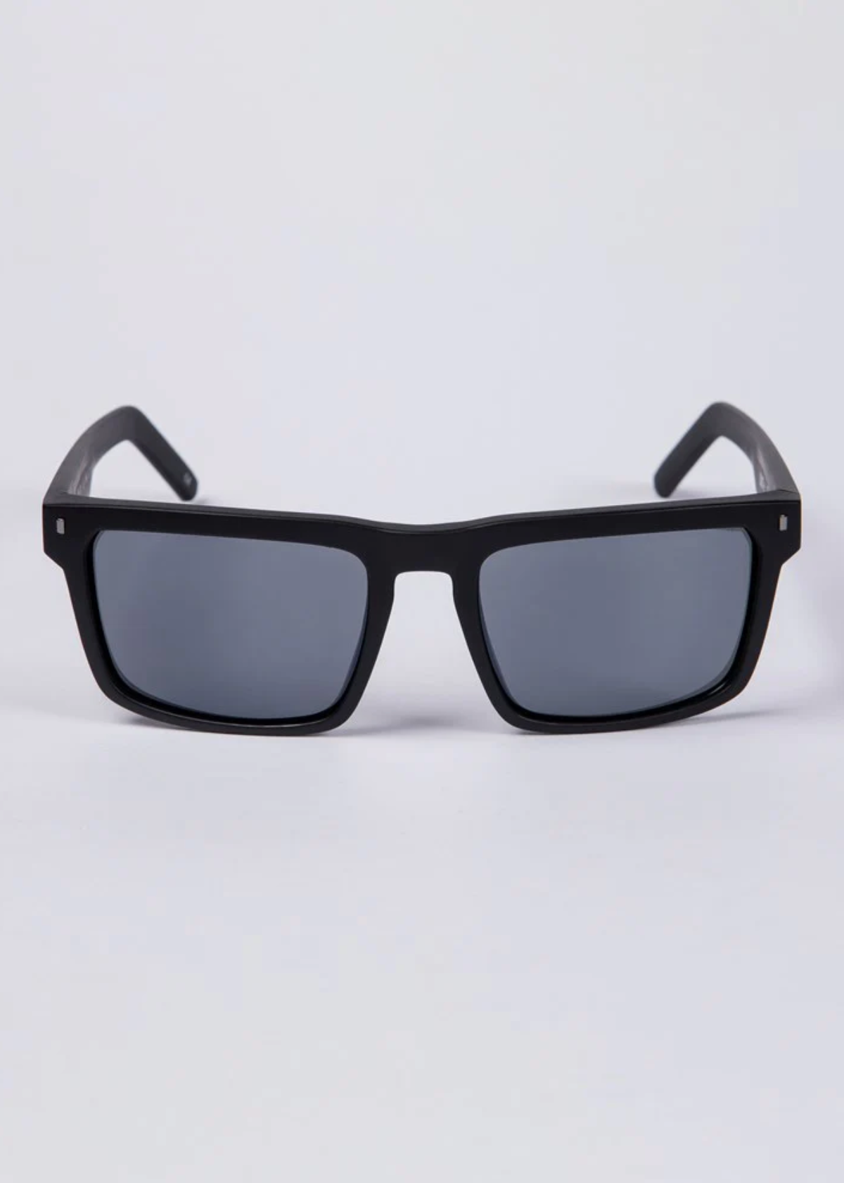 The UNIT Primer Polarised Eyewear features black rectangular frames with lightweight construction and dark UV-protective polarised lenses, shown facing forward against a plain white background.
