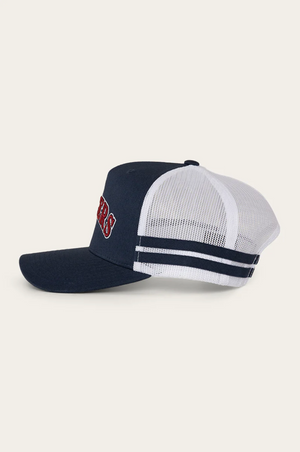 The Ringers Western Caleb Trucker Cap features a navy blue and white design with a mesh back, cotton twill navy bill, two navy stripes on the white adjustable strap, and red and white embroidered lettering on the front.