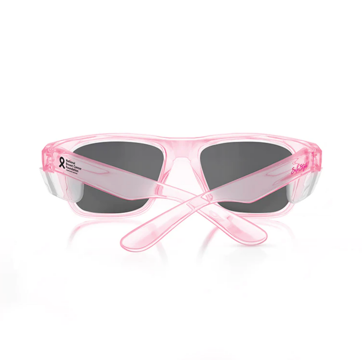 The image shows SafeStyle Fusions Pink Frame Tinted Lens sunglasses, viewed from the back with crossed arms. The left arm features a small breast cancer awareness ribbon and text.