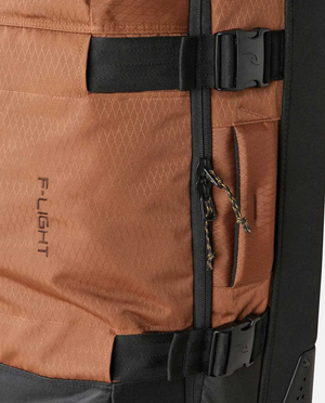 Close-up of the Rip Curl F-Light Global 110L Searchers Travel Bag, crafted from CORDURA Recycled Polyester with textured fabric, black compression straps and buckles, a zippered pocket with pull cord, and "F-LIGHT" branding on the side.
