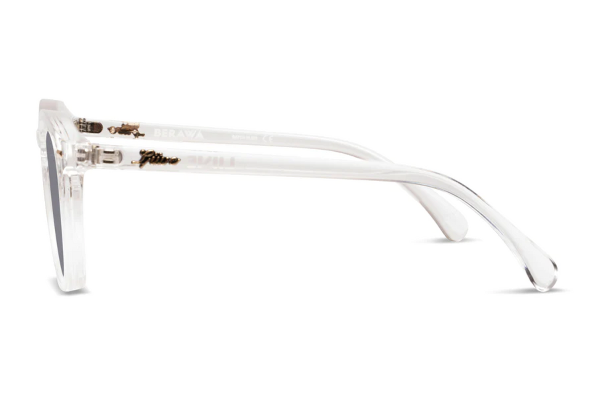 Side view of Liive Berawa Sunglasses featuring clear, lightweight polycarbonate frames, dark UV-protected lenses, and subtle gold hinge details, set against a white background.