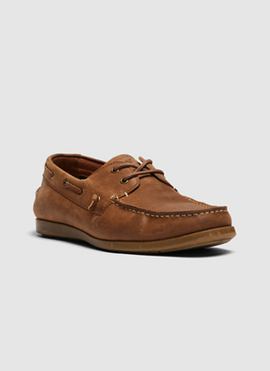 The Rodd & Gunn Gordons Bay Boat Shoe is a brown leather lace-up with white stitching and a slip-resistant rubber outsole, set against a plain gray background.