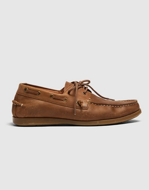 A side view of the Rodd & Gunn Gordons Bay Boat Shoe is set against a plain white background. It showcases a brown leather upper with lace detailing and eyelets, typical of boat shoes, paired with a visible rubber outsole at the base.