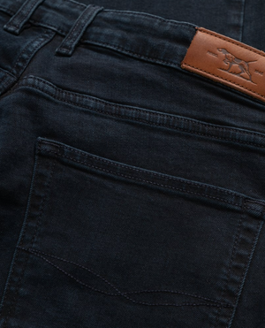 Close-up of Rodd & Gunn's Weston Straight Italian Denim Jeans in deep blue-black, showcasing a visible back pocket. Includes a brown leather patch on the waistband with a horse logo. The comfortable fit, detailed stitching, and fabric texture stand out vividly.
.