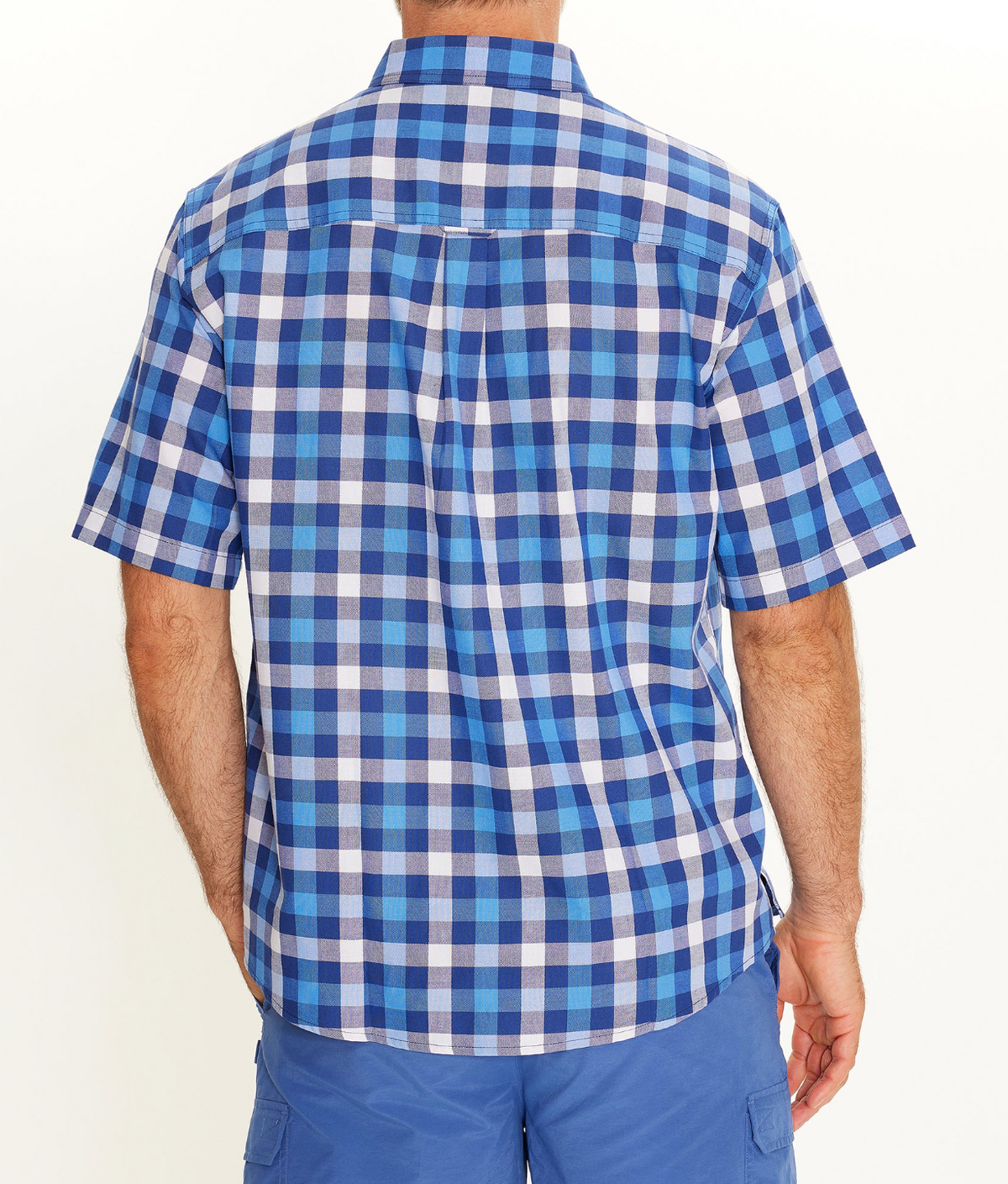A man is seen from behind wearing the Breakaway Gil Oxford Shirt, a short-sleeve blue and white plaid 100% cotton casual shirt, paired with blue shorts, against a plain white background.