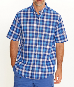 A man models the Breakaway Gil Oxford Shirt, a comfortable 100% cotton blue and white plaid casual shirt, paired with blue shorts against a plain white background. His face is mostly out of frame.